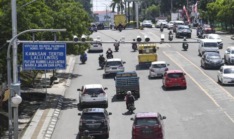 Pengendara melintas di bawah kamera pengawas atau Closed Circuit Television (CCTV) yang terpasang di Jalan Jenderal Sudirman, Palembang, Sumatera Selatan, Rabu (15/12/2021). Direktorat Lalu Lintas (Ditlantas) Polda Sumatera Selatan menargetkan penerapan tilang elektronik atau Electronic Traffic Law Enforcement (ETLE) mulai Januari 2022 mendatang dengan menambah sembilan kamera di sejumlah ruas jalan di Palembang.