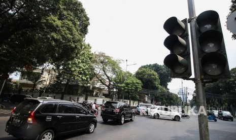 Pengendara melintas di dekat lampu lalu lintas yang tidak berfungsi di Jalan Diponegoro, Jakarta, Senin (5/8/2019).