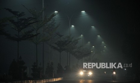 Pengendara melintas di jalan yang diselimuti kabut asap kebakaran hutan dan lahan. (ilustrasi). Pemkot Jambi membagikan masker gratis untuk mengantisipasi dampak asap.