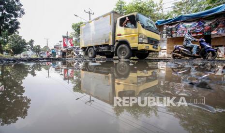 Pengendara melintas di jalan yang rusak serta beriubang di Jalan Raya Tegar Beriman, Cibinong, Kabupaten Bogor, Jawa Barat, Senin (19/4/2021). Menurut warga setempat rusaknya akses jalan menuju kawasan Pemerintahan Kabupaten Bogor tersebut sudah banyak menimbulkan kecelakaan. 