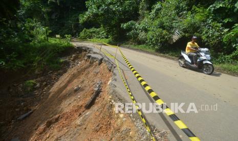 Pengendara melintas di samping badan jalan yang rusak akibat gempa, di Rimbo Kejahatan, Kabupaten Pasaman Barat, Sumatera Barat, Rabu (9/3/2022). Akses jalan dari Kabupaten Pasaman Barat ke Kabupaten Pasaman melalui Rimbo kejahatan masih banyak terdapat titik rawan longsor dan badan jalan yang rusak akibat gempa sehingga harus dilewati bergantian untuk mobil dan truk. 