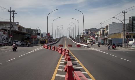 Pengendara melintas di samping jembatan Flyover Palur yang ditutup di Karanganyar, Jawa Tengah, Rabu (14/7/2021). Polres Karanganyar menutup total jalan layang atau flyover yang menghubungkan Kota Solo dengan Kabupaten Karanganyar tersebut untuk mengurangi mobilitas warga selama Pemberlakukan Pembatasan Kegiatan Masyarakat (PPKM) Darurat.