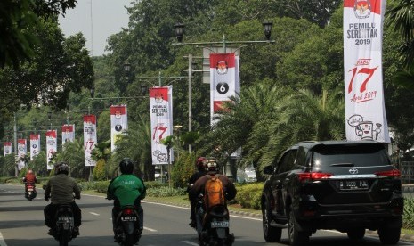 Pengendara melintas di samping spanduk sosialisasi Pemilu Serentak 2019 KPU di kawasan Jalan Imam Bonjol, Jakarta, Sabtu (7/7). 