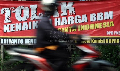  Pengendara melintas didepan spanduk penolakan kenaikan BBM di Jakarta, Jumat (7/6).  (Republika/Tahta Aidilla)