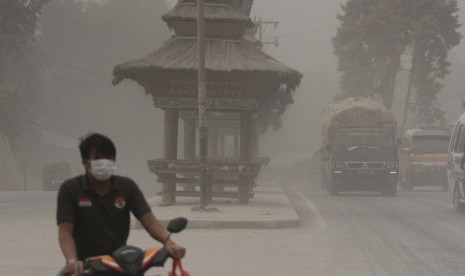 Pengendara melintas saat hujan abu vulkanik erupsi Gunung Sinabung, di Brastagi, Karo, Sumatera Utara, Jumat (26/6).