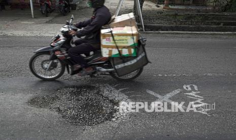 Pengendara melintasi jalan berlubang di Desa Kedung Benda, Kemangkon, Purbalingga, Jateng, Sabtu (5/6/2021). Jalan yang merupakan jalur utama menuju Bandara Jenderal Besar Soedirman Purbalingga dari arah Kabupaten Banyumas tersebut berlubang dan bergelombang, sehingga membahayakan dan menyulitkan akses pengguna jalan yang melintas maupun yang menuju Bandara yang baru saja beroperasi tersebut. 