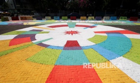 Pengendara melintasi Jalan Proklamasi yang dihiasi mural Asian Games 2018 di Jakarta, Jumat (27/7). 