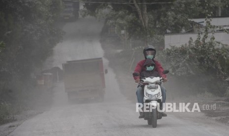 Pengendara melintasi kawasan yang terpapar abu vulkanis Gunung Agung di Desa Pemuteran, Karangasem, Bali, Jumat (29/6).