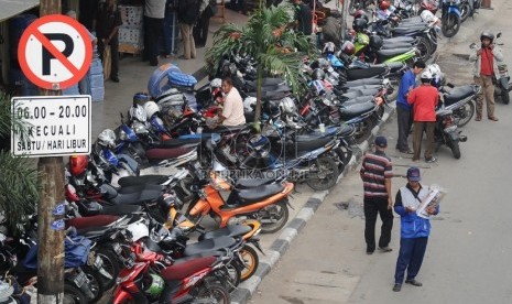  Pengendara memarkirkan kendaraannya di Trotoar Jalan Gajah Mada, Jakarta Barat, Rabu (1/4). 