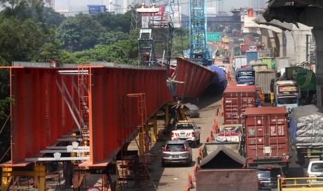 Pengendara memperlambat laju kendaraannya saat melintas di samping Steel I Girder (SIG) proyek jalan tol layang Jakarta-Cikampek yang membentang hingga sisi jalan, di Cikarang km 28 arah Cikampek, Kabupaten Bekasi, Jawa Barat, Rabu (22/5/2019). 