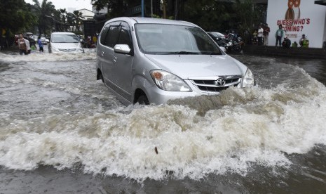 Pengendara mobil berusaha menerobos banjir di kawasan Kemang, Jakarta, Jumat (11/11). 