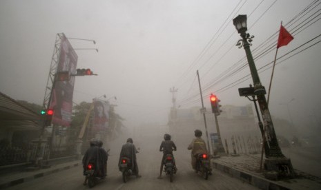  Pengendara motor berhenti di lampu merah ketika hujan abu vulkanik di Jl. Mataram, Yogyakarta, Jumat (14/2).    (Antara/Noveradika)