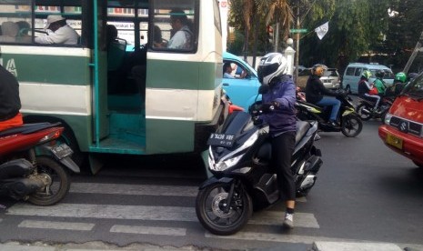 Pengendara motor dan mobil terlihat berhenti di zebra cross lampu merah jalan Ragunan Raya.  Bahkan, ada beberapa pengendara berhenti di luar batas penyeberangan, Jakarta, Kamis (1/8). 