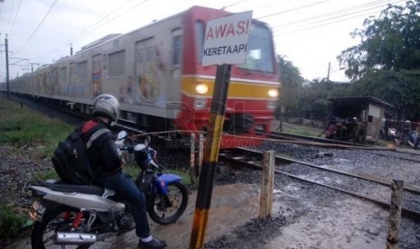  Pengendara motor di perlintasan kereta api tanpa palang pintu. (ilustrasi)