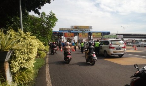 Pengendara motor dialihkan masuk tol Taman Mini 2, Makasar, Jakarta Timur, Kamis (21/4).