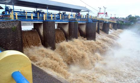 Pengendara motor melaju di atas jembatan Bendung Katulampa, Kota Bogor, Jawa Barat, Ahad (7/2/2021). Badan Penanggulangan Bencana Daerah (BPBD) DKI Jakarta menyebutkan Bendung Katulampa berstatus siaga tiga dengan ketinggian muka air mencapai 130 cm akibat curah hujan tinggi di Bogor sehingga warga di bantaran sungai Ciliwung, Jakarta harus waspada terhadap potensi banjir.