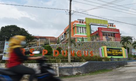 Pengendara motor melaju di depan Rumah Sakit Umum (RSU) Dungus, Kabupaten Madiun, Jawa Timur, Jumat (8/1/2021). Pemprov Jawa Timur membangun rumah sakit lapangan berkapasitas 140 pasien di kawasan RSU Dugus untuk penanganan pasien positif COVID-19 dengan kondisi ringan dan sedang menyusul meningkatnya jumlah kasus positif COVID-19 di daerah tersebut.