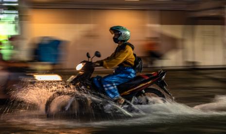 Pengendara motor melaju di jalan yang terendam banjir di Jalan Gajah Raya, Kota Semarang, Jawa Tengah.