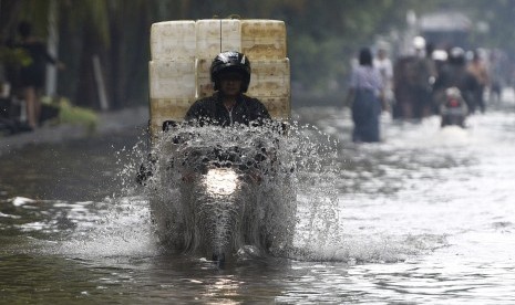 Pengendara motor melewati banjir yang melanda Jalan Gaya Motor, Sunter, Jakarta Utara, Kamis (25/2).