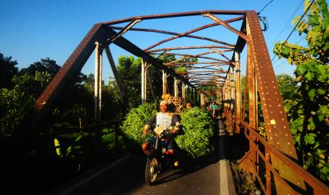 Pengendara motor melewati jembatan besi peninggalan dari masa penjajahan Belanda di Desa Bae, Kudus, Jawa Tengah, Senin (30/5/2022). Jembatan dengan panjang kurang lebih 50 meter dan lebar 2,5 meter yang dahulu digunakan sebagai jalur pengangkutan hasil pertanian pada masa penjajahan belanda itu kondisinya masih kokoh dan digunakan warga untuk aktivitas sehari-hari.