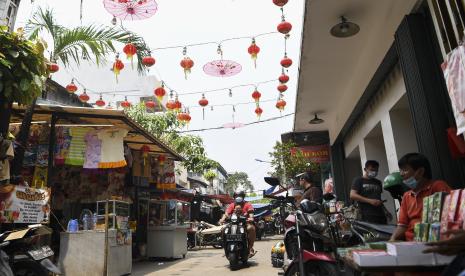 Pengendara motor melintas di dekat lapak pedagang kaki lima (PKL) di kawasan Petak Sembilan, Glodok, Jakarta, Selasa (5/4/2022). Sebanyak 160 PKL di kawasan Petak Sembilan rencananya akan direlokasi ke Pasar Glodok agar jalan tersebut bisa dilalui kendaraan mobil dan motor, sejalan dengan penataan kawasan Kota dalam menyambut Stasiun MRT Taman Sari.