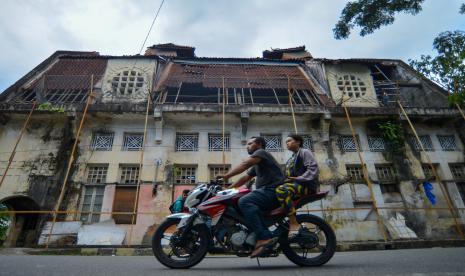 Pengendara motor melintas di depan gedung Geo Wehry & Co yang sedang dibongkar atapnya di kawasan kota tua Padang, Sumatera Barat. Bank Indonesia (BI) perwakilan Sumatra Barat mencatat Indeks Harga Konsumen (IHK) di provinsi itu mengalami inflasi sebesar 7,43 persen pada 2022, melonjak dibandingkan 2021 yang hanya 1,40 persen.