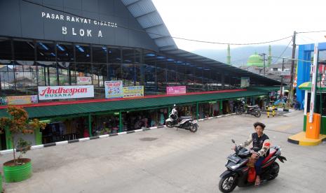 Pengendara motor melintas di depan Pasar Rakyat Cisarua, Kabupaten Bogor, Jawa Barat. Pemerintah Provinsi Jawa Barat terus menambah jumlah pasar rakyat yang direvitalisasi, salah satunya Pasar Rakyat Cisarua yang merupakan pasar terluas di Jawa Barat dengan anggaran sebesar Rp29 miliar yang berasal dari Pemprov Jabar dan Pemkab Bogor. 