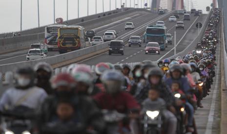 Pemudik yang menggunakan sepeda motor melintas di Jembatan Suramadu, Surabaya, Jawa Timur. 