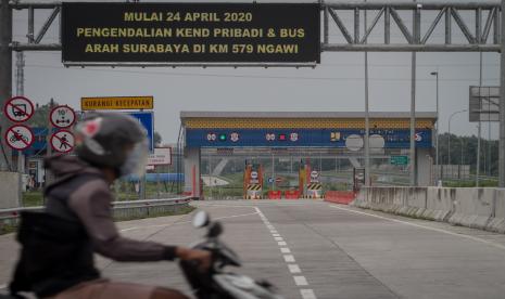 Pengendara motor melintas di kawasan gerbang tol Solo-Ngawi Gondang Rejo, Karanganyar, Jawa Tengah, Selasa (28/4/2020). Menurut PT. Jasamarga Solo Ngawi sampai dengan April jumlah kendaraan yang melintas jalan tol menurun hingga 50 persen dan diprediksi akan terus menurun seiring penerapan larangan mudik dan pemberlakukan Pembatasan Sosial Berskala Besar (PSBB) kota di Jawa Timur.