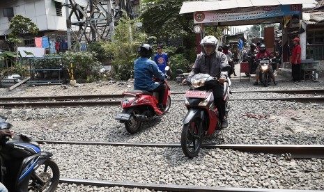 Pengendara motor melintas di perlintasan kereta api tanpa palang pintu di kawasan Petamburan, Jakarta, Selasa (2/7/2019). 