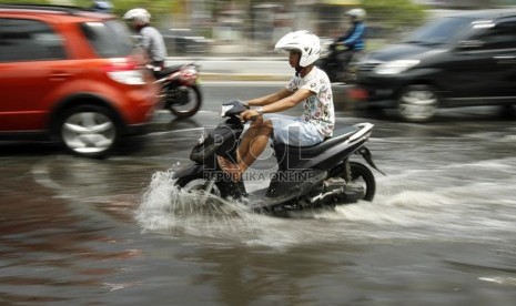  Pengendara motor melintasi jalan yang tergenang air di kawasan Gunung Sahari, Mangga Dua, Jakarta Utara, Jumat (14/12).   (Republika/Adhi Wicaksono)