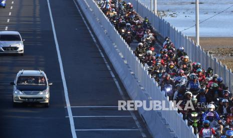 Pengendara motor melintasi Jembatan Suramadu di Bangkalan, Jawa Timur, Kamis (30/7/2020). Kementerian Perhubungan (Kemenhub) mencatat adanya peningkatan pergerakan penumpang transportasi umum pada masa Libur Idul Adha di terminal, stasiun, bandara, dan pelabuhan. Juru Bicara Kemenhub Adita Irawati mengatakan puncak arus balik Idul Adha 2020 akan terjadi pada hari ini, Ahad (2/8).