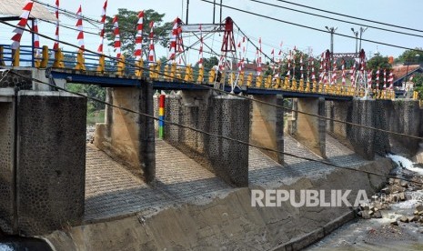 Pengendara motor melintasi sungai Ciliwung di jembatan Bendung Katulampa, Kota Bogor, Jawa Barat, Kamis (15/8/2019). Hingga pukul 10.00 WIB, tinggi muka air (TMA) di Bendung Katulampa Kota Bogor, yang mengalir ke Sungai Ciliwung terpantau berada di posisi terpantau Siaga IV.