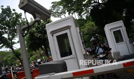 Pengendara motor membayar parkir di lapangan IRTI Monas, Jakarta Pusat, Jakarta, Senin (10/12/2018).