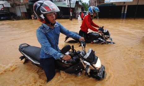 Pengendara motor nekat melewati banjir yang merendam Jalan Adinegoro, Padang, Sumatera Barat, Selasa (22/3).