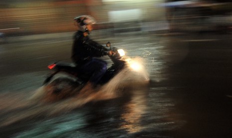 Pengendara motor nekat menerobos banjir di depan Masjid Nurul Iman, Padang, Sumatera Barat, Sabtu (9/9). 