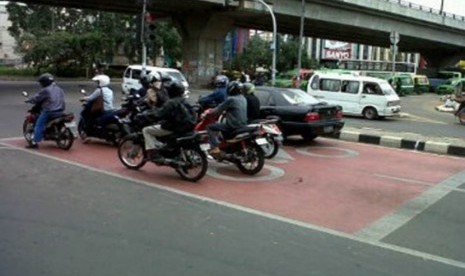 Pengendara motor saat berhenti di Red Box di Jalan Sudirman, Tangerang, Jumat (30/12).