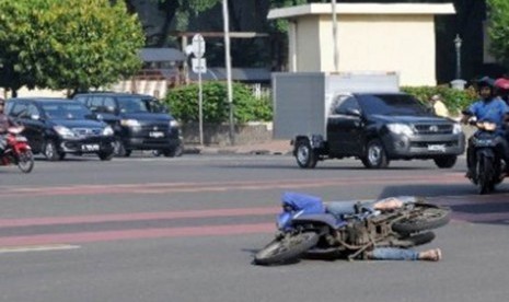 Pengendara motor terjatuh saat bersinggungan dengan kendaraan lain di persimpangan Sarinah, Jakarta Pusat, Selas (21/2). 