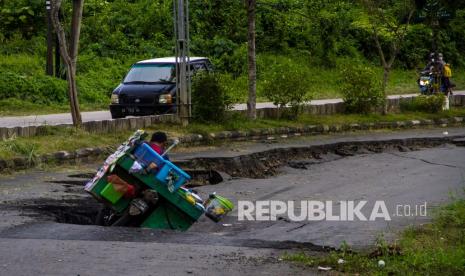 Pengendara motor terjatuh saat melintas di Jalan Nasional Ahmad Yani yang longsor di Kabupaten Balangan, Kalimantan Selatan, Jumat (11/2/2022). Jalan Nasional penghubung antar Provinsi Kalimantan Selatan-Kalimantan Timur tersebut mengalami longsor sejak satu tahun lalu hingga kini belum diperbaiki sehingga dapat membahayakan warga yang melintas di jalan tersebut.