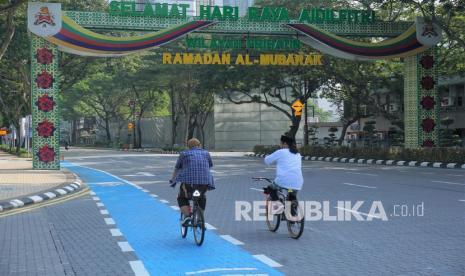 Pengendara sepeda melintas di gapura ucapan Idul Fitri 1442 H yang dipasang di depan Bandaraya (Pemerintah Kota) Kuala Lumpur Jalan Raja Laut Kuala Lumpur, Malaysia, Kamis (13/5/2021). Suasana relatif sepi seiring penerapan Perintah Kawalan Pergerakan (PKP) untuk membendung penyebaran COVID-19.