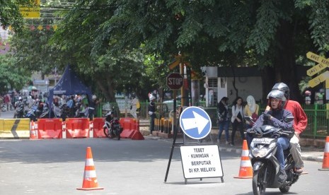 Pengendara sepeda motor berputar arah saat akan melintas di jalur perlintasan kereta api listrik (KRL) yang sudah ditutup di pintu perlintasan stasiun Tebet Jalan Abdullah Syafii, Jakarta Selatan, Kamis (7/4).