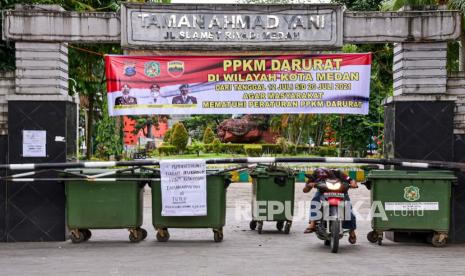 Penerangan Jalan di Medan Dimatikan Selama PPKM Darurat. Pengendara sepeda motor keluar dari area Taman Ahmad Yani yang ditutup selama masa Pemberlakuan Pembatasan Kegiatan Masyarakat (PPKM) Darurat di Kota Medan, Sumatera Utara, Selasa (13/7/2021). Pemerintah Kota Medan menutup seluruh taman kota atau Ruang Terbuka Hijau (RTH) yang ada di Medan demi mencegah kerumunan dan meredam penyebaran COVID-19 selama PPKM darurat.