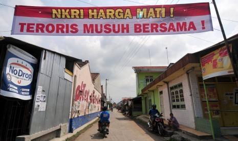  Pengendara sepeda motor melaju di bawah spanduk berisi penolakan terhadap teroris di Desa Pegirikan, Kabupaten Tegal, Jawa Tengah, Selasa (19/1). 