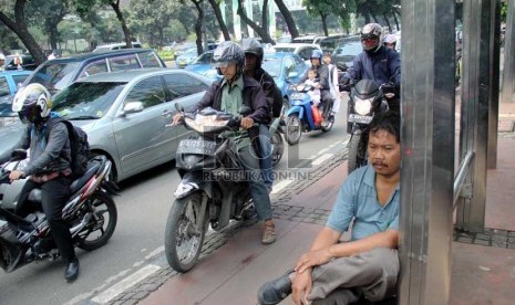   Pengendara sepeda motor melaju di trotoar di Jalan Sudirman, Jakarta Pusat, Jumat (19/7).    (Republika/ Yasin Habibi)