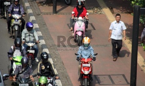   Pengendara sepeda motor melaju di trotoar di Jalan Sudirman, Jakarta Pusat, Jumat (19/7).    (Republika/ Yasin Habibi)