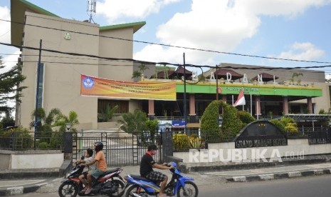 Pengendara sepeda motor melintas dekat Hotel Grand Madani di Mataram, NTB, Ahad (4/6). 