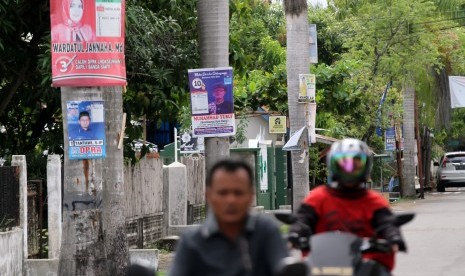 Pengendara sepeda motor melintas di jalan yang masih terdapat Alat Peraga Kampanye (ilustrasi)