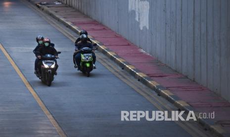 Pengendara sepeda motor melintas di kawasan Tanah Abang, Jakarta, Ahad (3/5/2020). Polda Metro Jaya mencatat sebanyak 39.999 pengendara melanggar aturan Pembatasan Sosial Berskala Besar (PSBB) di DKI Jakarta sejak 13 April dan 2 Mei dengan pelanggar terbanyak pengendara sepeda motor. 