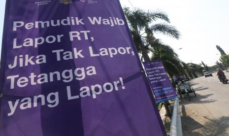 Pengendara sepeda motor melintas di samping spanduk sosialisasi aturan pemudik wajib lapor di Kota Kediri, Jawa Timur, Rabu (22/4). Pemerintah pusat telah secara tegas melarang masyarakat mudik mulai Jumat (24/4),