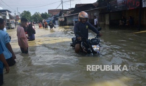 Pengendara sepeda motor melintasi banjir di Desa Gubug, Gubug, Grobogan, Jawa Tengah, Kamis (9/1/2020).